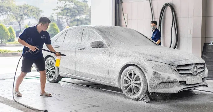 Một người đang rửa xe bằng dung dịch chuyên dụng, giữ lớp phủ ceramic bền đẹp