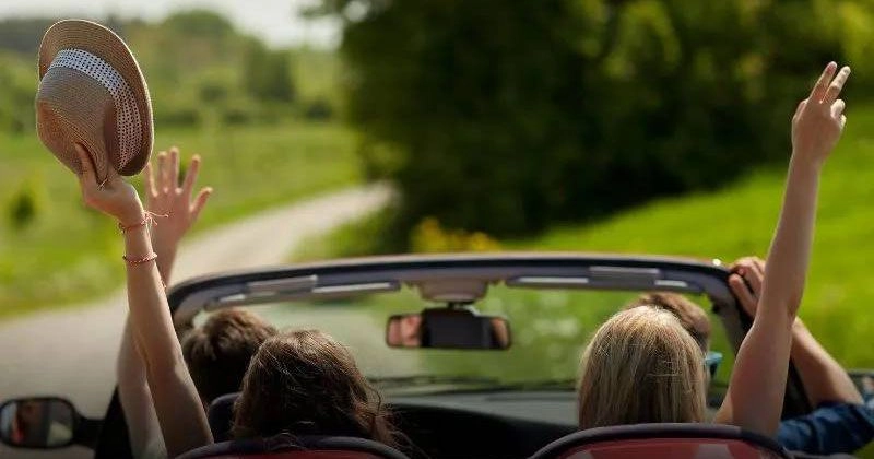 Một nhóm bạn trẻ vui vẻ bên chiếc xe được bảo dưỡng tốt, sẵn sàng cho chuyến đi