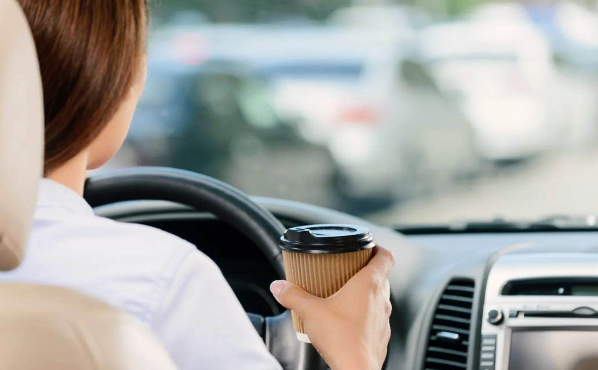 Một tài xế đang nghỉ ngơi bên đường với cốc cà phê trên tay