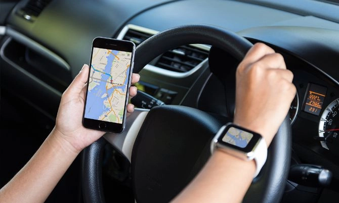 Một tài xế sử dụng điện thoại với ứng dụng Google Maps trong xe