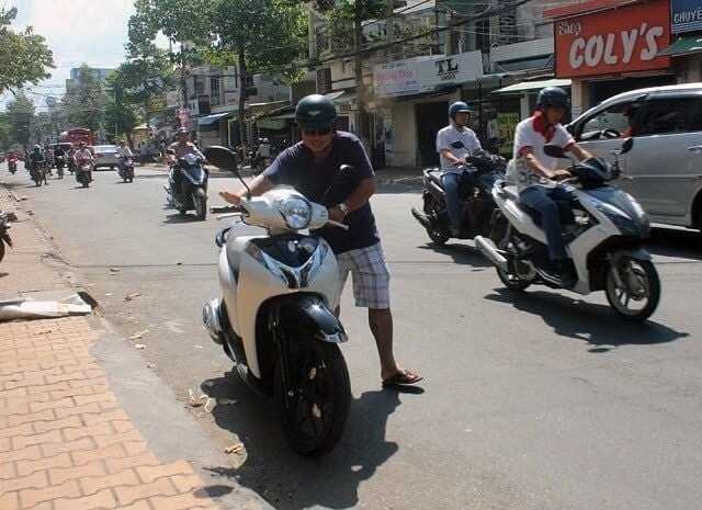 Một người thất vọng bên chiếc xe máy cũ bị hỏng
