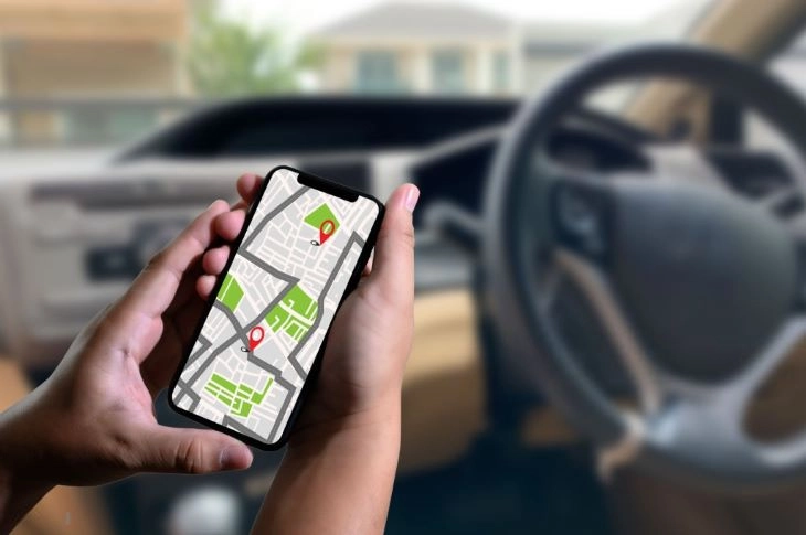 Một người đang xem bản đồ định vị trên điện thoại trước khi lái xe