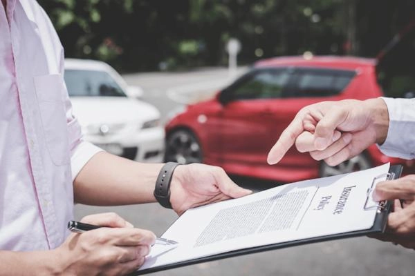  Một nhân viên văn phòng đăng ký xe đang kiểm tra giấy tờ bên cạnh chiếc xe ô tô
