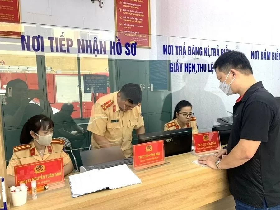 Một người đang nộp hồ sơ tại quầy giao dịch của cơ quan đăng ký xe