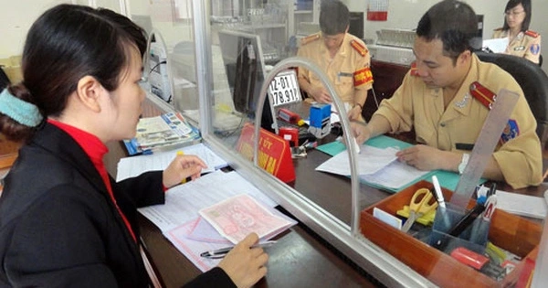 Một người đang nộp hồ sơ sang tên xe ô tô tại quầy giao dịch của cơ quan đăng ký xE