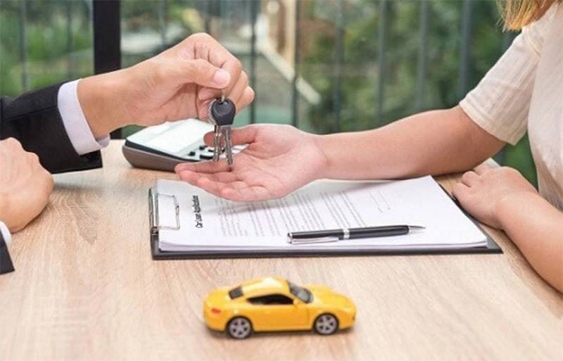 Một bộ hồ sơ sang tên xe ô tô được sắp xếp gọn gàng trên bàn làm việc, bên cạnh chiếc chìa khóa xe