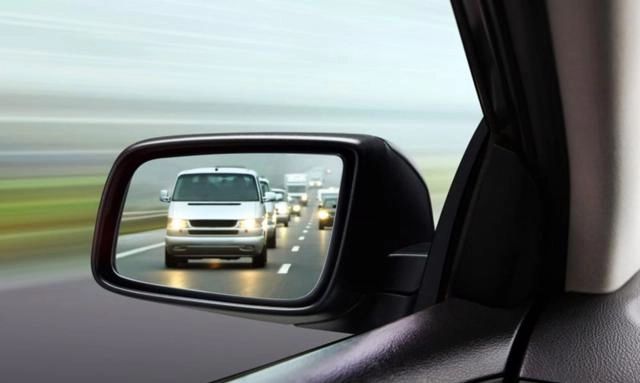 Gương chiếu hậu phản ánh xe phía sau, minh họa kỹ năng quan sát gương khi lái xe thành phố