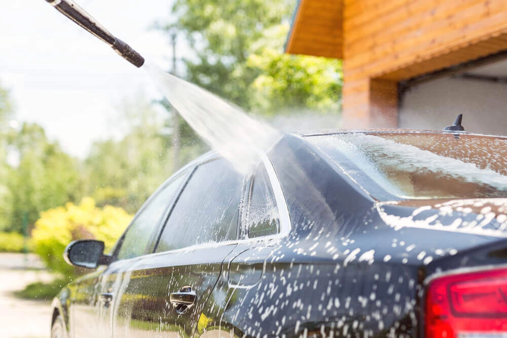 Rửa xe đúng cách tại nhà bắt đầu bằng việc xịt nước từ trên xuống để làm sạch bụi bẩn